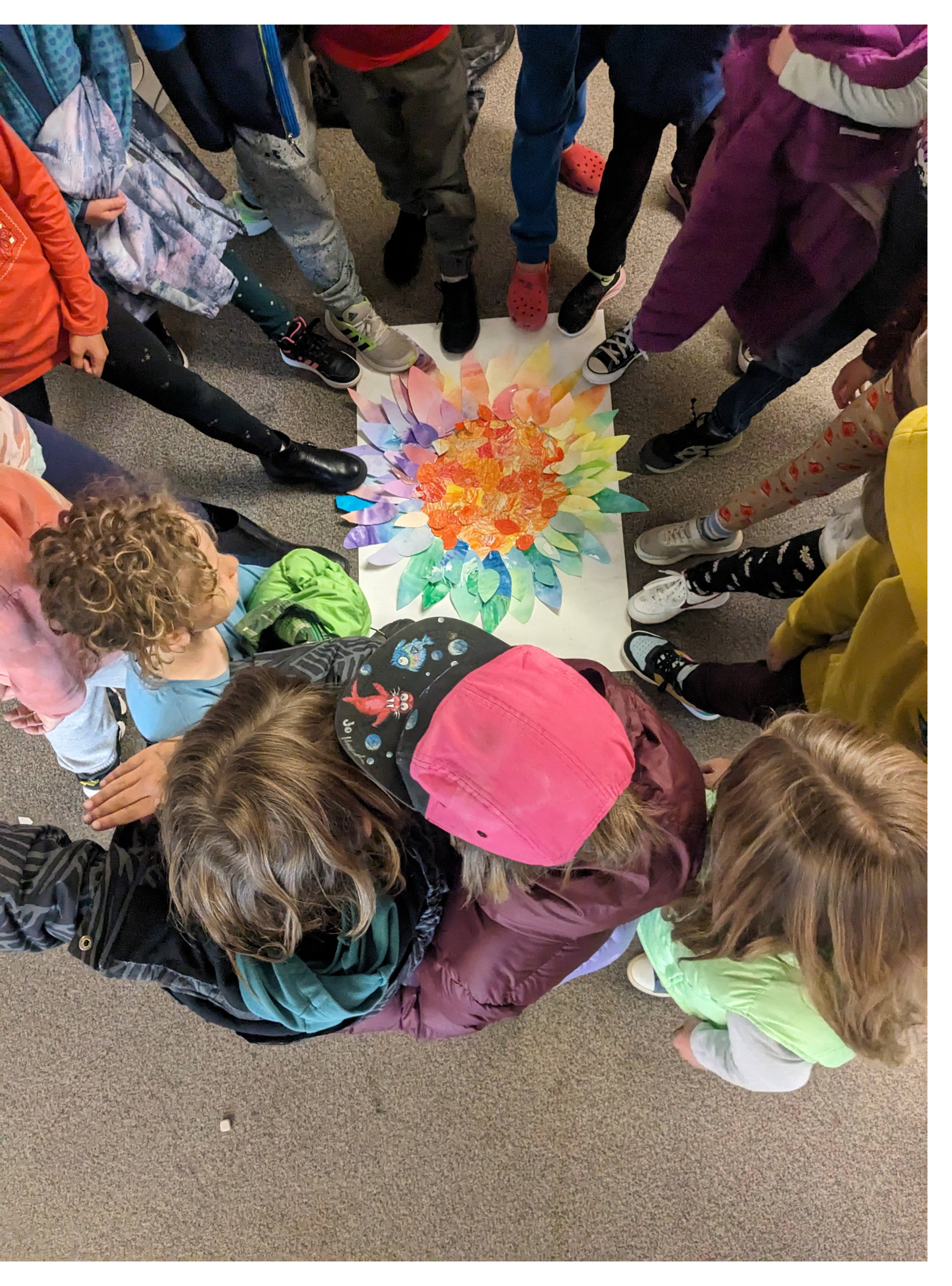 Elementary Students Standing in Circle Around Joint Art Project